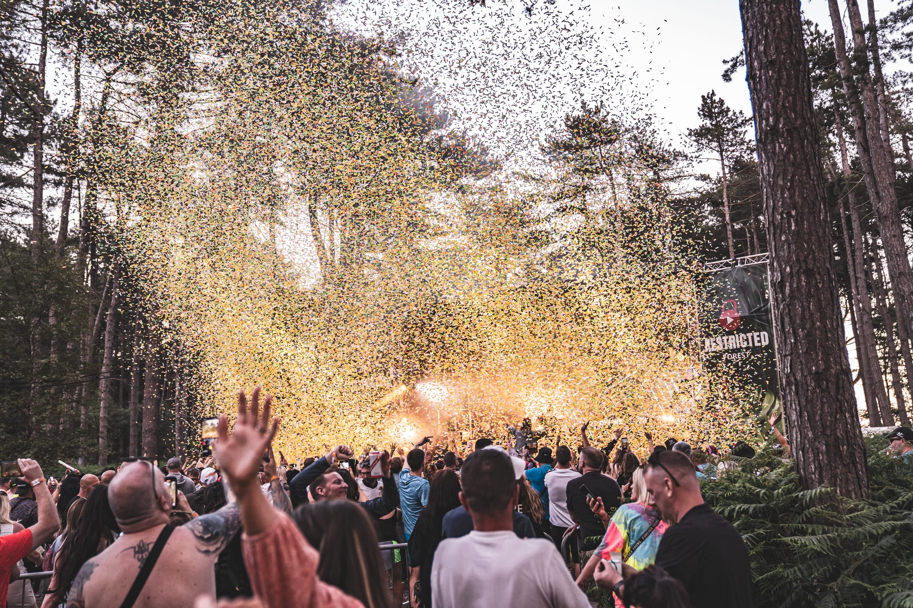 Confetti cannon firing over the crowd, canopy above.