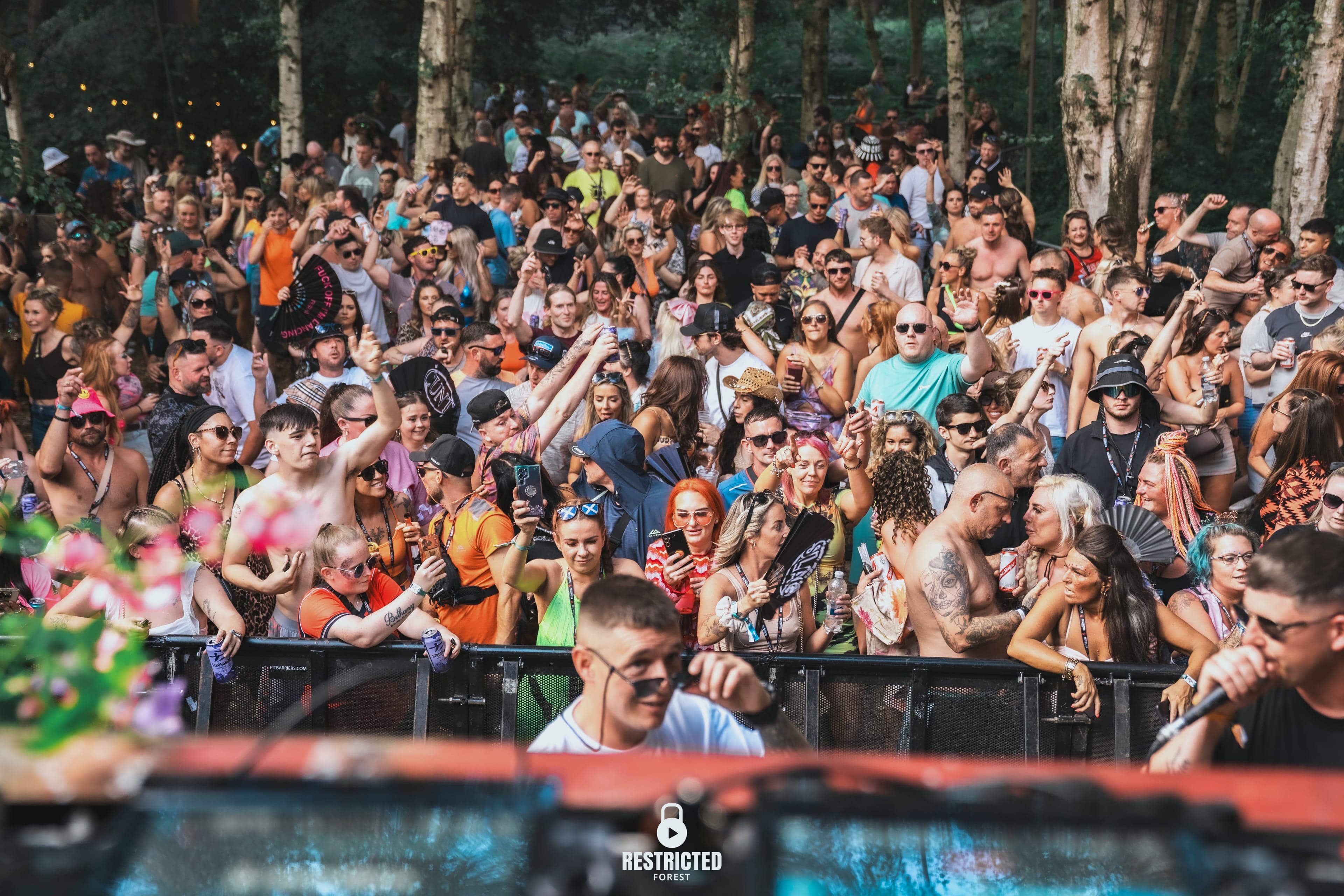 The crowd packed shoulder to shoulder in daylight, faces turned up to the stage